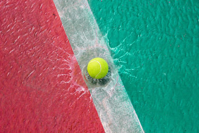 High angle view of yellow ball splashing into water