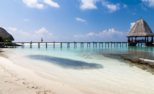 Pier on sea with sky in background