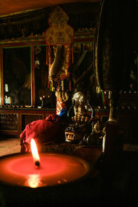 Midsection of man with sculpture in illuminated room