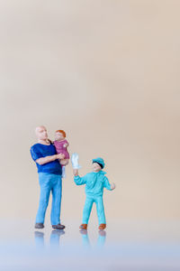Full length of father and son against white background
