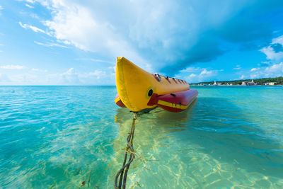 Yellow flag on sea against sky