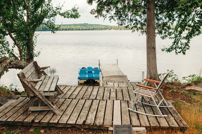 Wooden dock pier with wooden chairs on cottage lake in muskoka ontario canada 