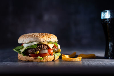 Close-up of burger on table against black background