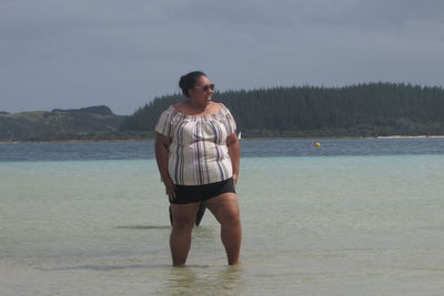 Full length of man standing on beach against sky