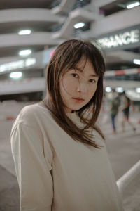 Portrait of young woman standing in bus