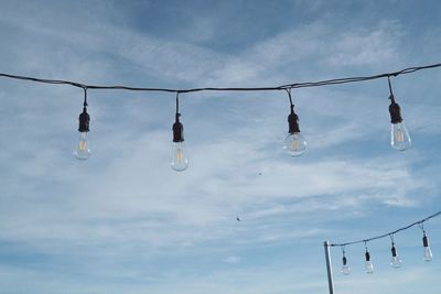 Low angle view of cables hanging against sky