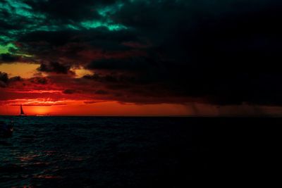 Scenic view of sea against dramatic sky during sunset