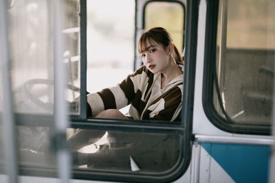 Portrait of woman looking through window