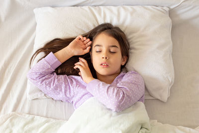 Cute girl sleeping on bed at home