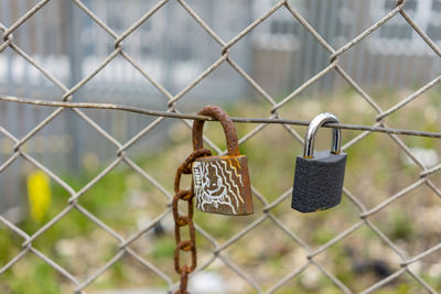 Close-up of padlocks on chainlink fence