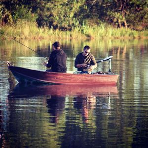 Men sitting on boat in lake