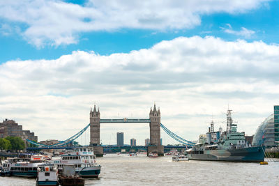 Boats and ship sailing on thames river by tower bridge against sky