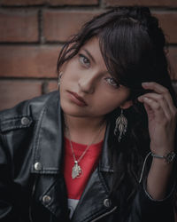 Portrait of young woman against black wall