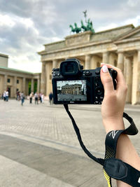 Person photographing with camera berlin gate brandenburg 