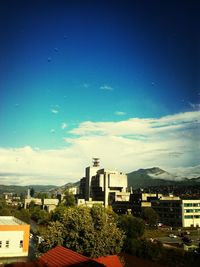 Buildings in town against cloudy sky