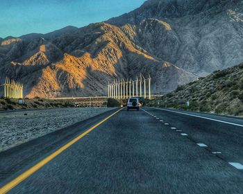 Vehicles on road against mountain range