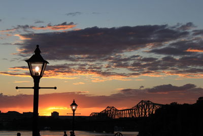 Street light against cloudy sky during sunset