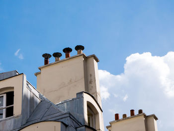 Low angle view of chimneys on building against sky in paris