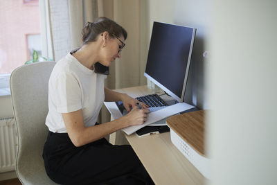 Woman at desk using cell phone