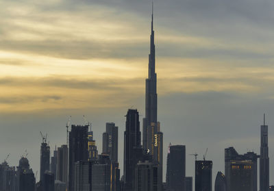 Modern buildings against sky during sunset