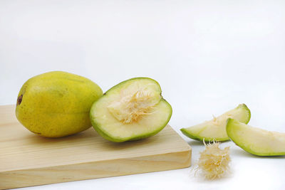 Close-up of fruits on table against white background