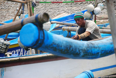 Fisherman working on boat at harbor