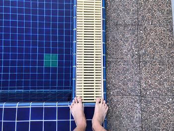 Low section of man standing at poolside