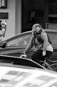 Full length of woman sitting on car