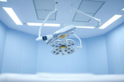 Low angle view of illuminated lighting equipment hanging on ceiling