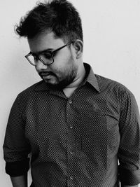 Portrait of young man standing against wall