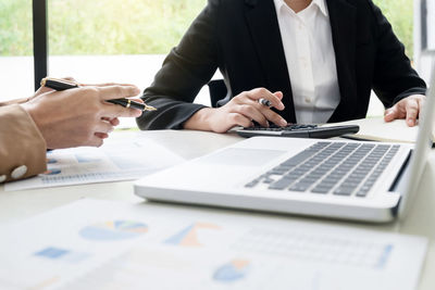 Midsection of man using laptop on table