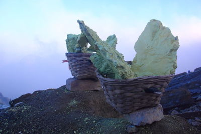 Close-up of rocks on rock against sky