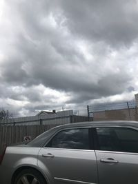 View of bridge in city against cloudy sky