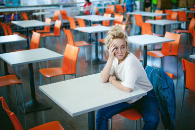 Woman sitting on chair at supermarket