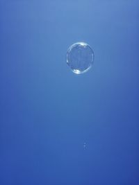 Low angle view of moon against blue sky