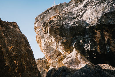 Low angle view of rock formation against sky