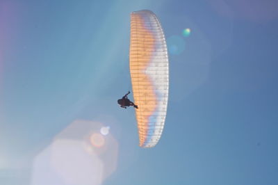 Low angle view of person paragliding against sky