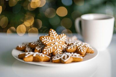 Ginger christmas cookies on the background of a christmas tree with lights.