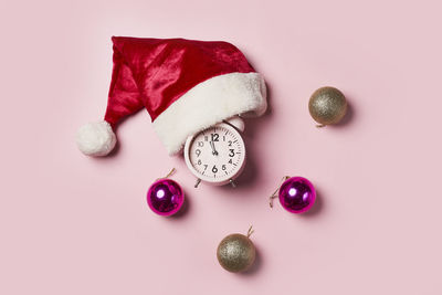 Directly above shot of christmas decorations on pink background