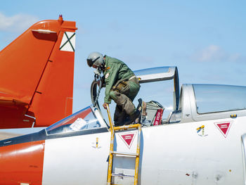 Man on airplane against sky