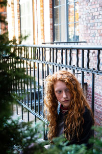 Portrait of woman against brick wall