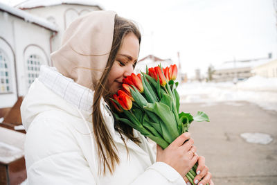 Girl with a bouquet of tulips at the train station, international women's day