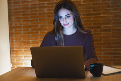 Young woman using laptop at table