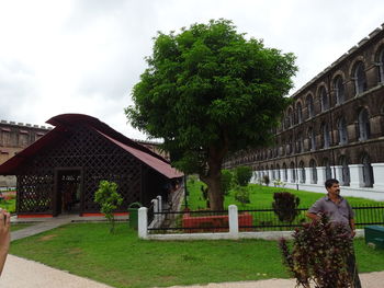 People standing by tree against building