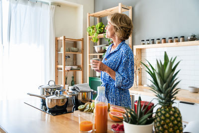 Rear view of woman sitting on table at home
