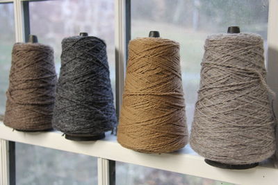 Close-up of colorful thread spools by window
