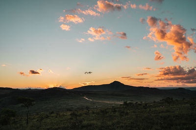 Scenic view of silhouette field against sky during sunset