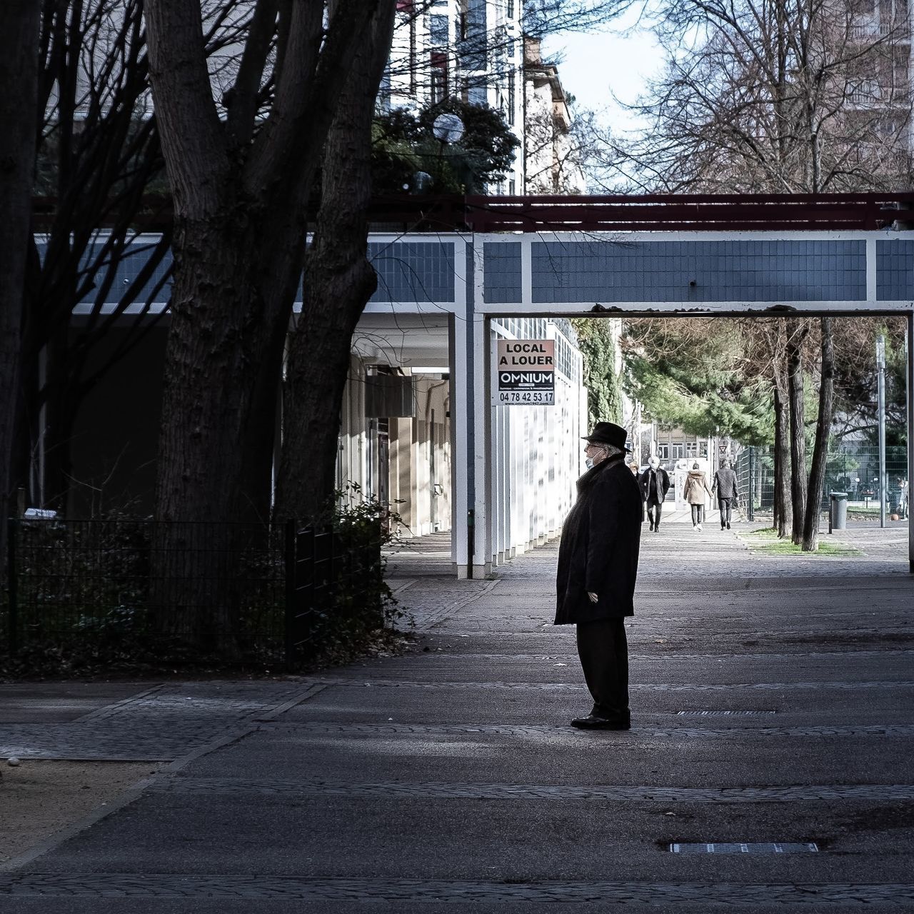 FULL LENGTH REAR VIEW OF WOMAN WALKING ON STREET AGAINST BUILDINGS