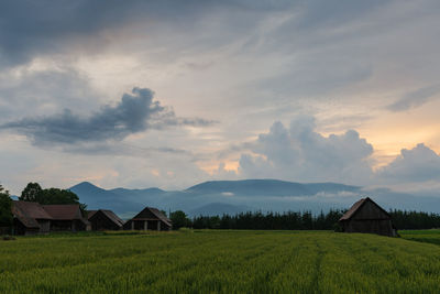 Clearing storm over a rural landscape with a traditional barn.