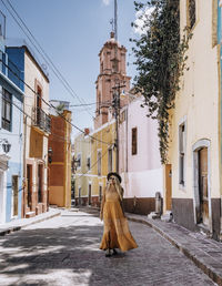 A young woman wearing in the streets of a colorful mexican town.